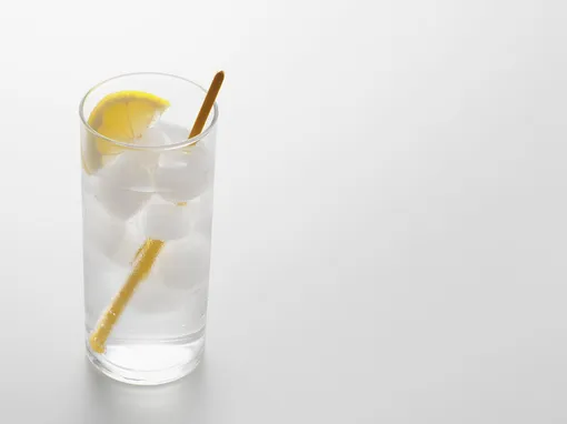 Стакан с газированной водой, льдом, трубочкой и лимоном